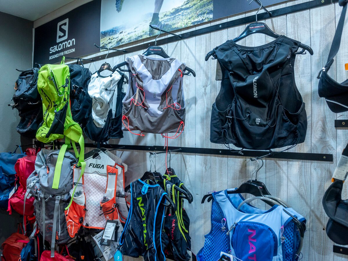 Expositor de mochilas y chalecos técnicos de trail running en tienda
